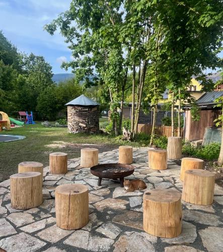 a group of tree stumps with a bench and a table at Apartmány U Šťastných in Cerny Dul