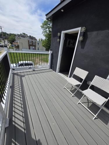 a deck with two chairs and a door to a building at G O G Building in Darby