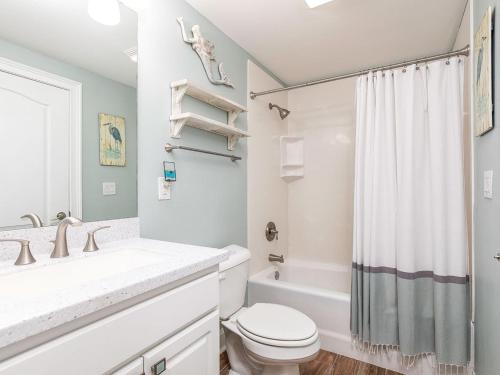 a white bathroom with a toilet and a shower at Gull Reef 633 in Tybee Island