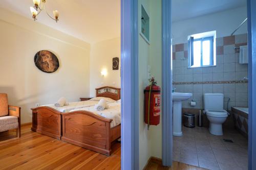 a bedroom with a bed and a bathroom at Taletos Apartments in Stoupa