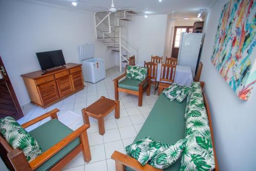 a living room with a couch and chairs and a tv at Casa Residencial Jerusalém II in Santa Cruz Cabrália