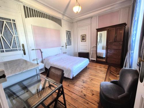 une chambre avec un lit, une table et une chaise dans l'établissement Résidence Le Splendide - Dans ancien palace à proximité des Thermes Chevalley, magnifique vue sur ville et lac, au calme ! MAE-7614, à Aix-les-Bains