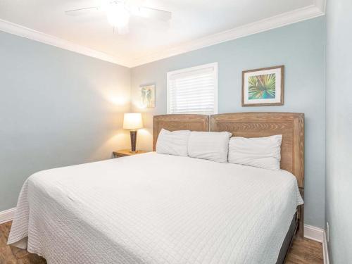 a bedroom with a large bed with white sheets at Dune B in Tybee Island