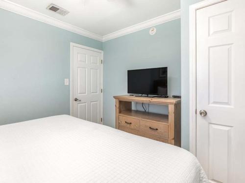 a bedroom with a bed and a flat screen tv at Dune B in Tybee Island