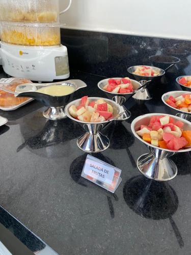 un mucchio di ciotole piene di frutta su un bancone di Hotel Maria Araújo ad Arapiraca