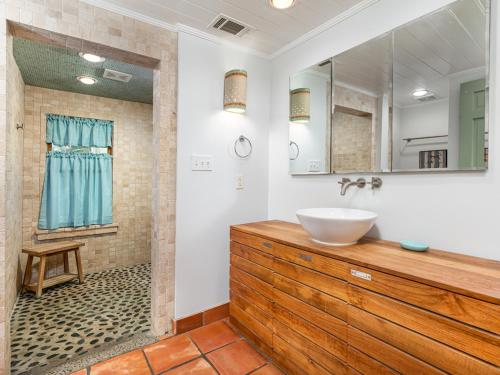 a bathroom with a sink and a mirror and a shower at Guiding Light Cottage in Tybee Island