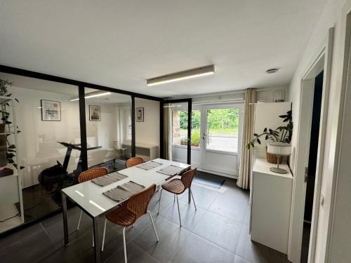 une salle à manger avec une table et des chaises blanches dans l'établissement Logement en face du Parc, à Obernai