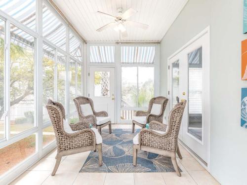a room with four chairs and a ceiling fan at Driftaway in Tybee Island