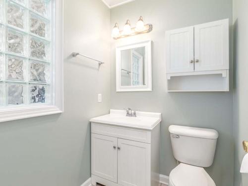a white bathroom with a toilet and a sink at Driftaway in Tybee Island
