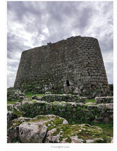 a large stone building on top of some rocks at La casa di nonno in Ghilarza