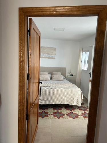 a bedroom with a bed and a door open at casa los almendros in Confrides