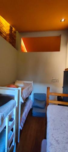 a room with three bunk beds and a chair at Hospedaria Casa373 valores acessíveis Vila Mariana e Vila Clementino in Sao Paulo