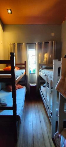 a room with four bunk beds and a window at Hospedaria Casa373 valores acessíveis Vila Mariana e Vila Clementino in Sao Paulo