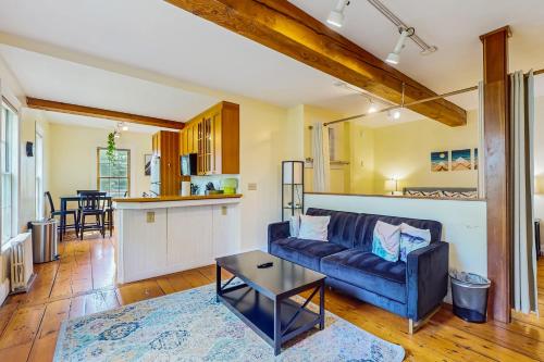 a living room with a couch and a kitchen at Stowe Mountain Road Escape in Stowe