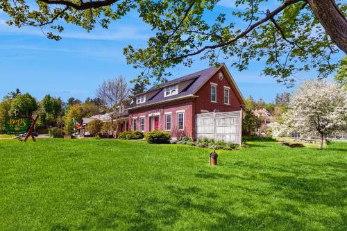 a red house on a green lawn with a fire hydrant at Stowe Mountain Road Escape in Stowe