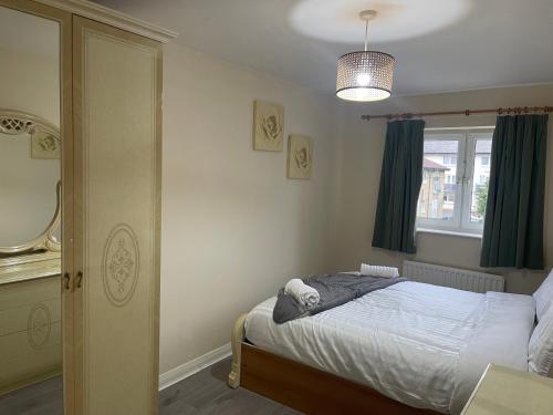 une petite chambre avec un lit et un miroir dans l'établissement 2 Bed Flat close to New Cross Gate, SE14, à Londres