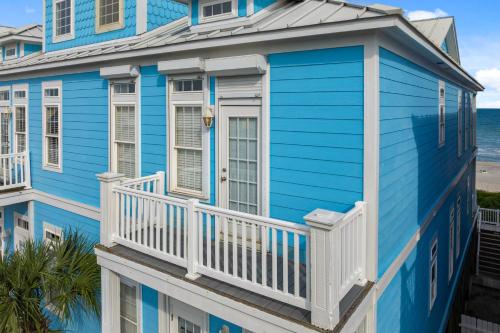 a blue house with a white balcony and the ocean at My Turn at Surf City in Surf City