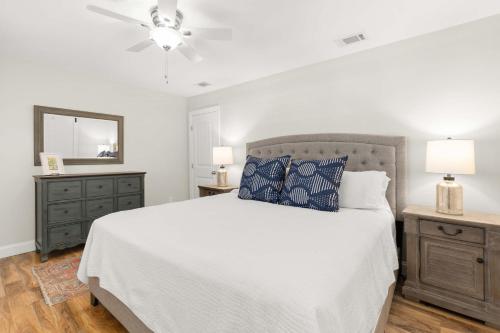 a bedroom with a white bed and a ceiling fan at Colonels Retreat in Tybee Island