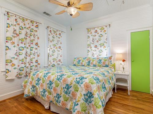 een slaapkamer met een bed en een plafondventilator bij Coastal Soul Cottage in Tybee Island