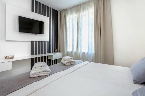 a bedroom with a white bed with towels on it at Sunset Split Rooms in Podstrana