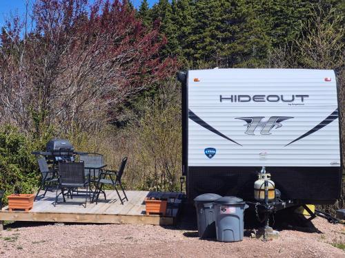 a white truck parked next to a table and chairs at Moceanset Getaways - Elegant, Ocean, Mountain and Sunset Views "Camping Experience" in Dingwall