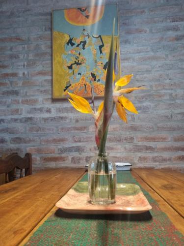 a vase with yellow flowers sitting on a table at ROSALIMON in Nueva Palmira