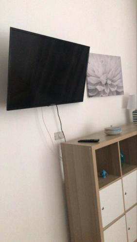 a flat screen tv hanging on a wall at Appartamento 140 mq a pochi minuti da Tropea, 2 bagni in Le Pioppe