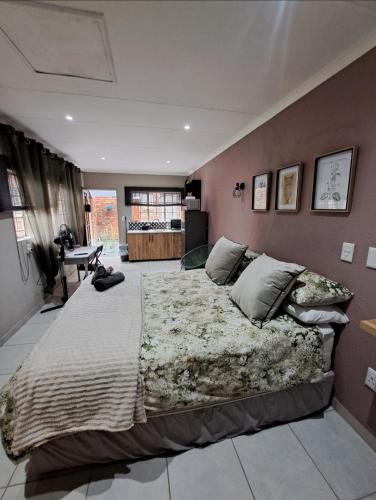ein Schlafzimmer mit einem großen Bett in einem Zimmer in der Unterkunft Sweetpea in Boksburg