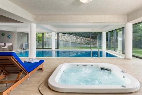 a large tub in a room with a swimming pool at Wellness Villa Biocrystal in Bakarac