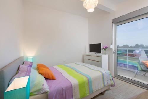 a bedroom with a bed and a view of a balcony at Villa Tammy by Villa Plus in Vodnjan