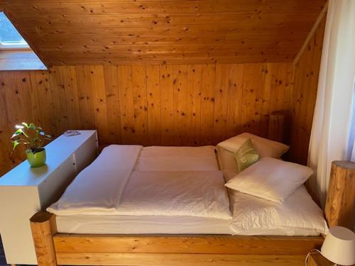 a room with a bed in a wooden room at Haus Bergblick in Größing