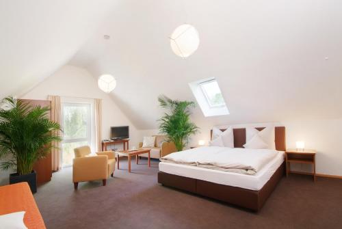 a bedroom with a bed and a desk and chairs at Gästehaus am Schloss in Schwebheim