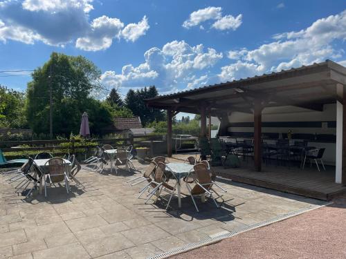 a group of tables and chairs in a patio at Les Charmois - Spa privatif en supplément et sur un autre site in Bains-les-Bains