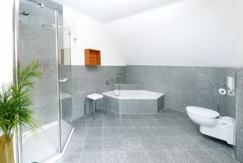 a bathroom with a tub and a toilet and a shower at Gästehaus am Schloss in Schwebheim