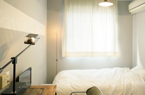 a bedroom with a bed and a desk with a lamp at Apartment Hotel Shinjuku in Tokyo