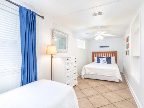 Un dormitorio con dos camas y un ventilador de techo. en Bikini Bottom, en Tybee Island