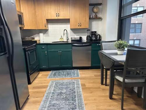 a kitchen with green cabinets and a table with a sink at Philadelphia Studio in Philadelphia