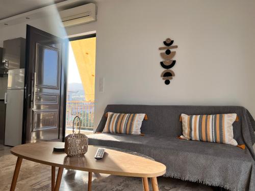 una sala de estar con un sofá y una mesa en Kyklamino Apartment, en Loutra Oraias Elenis