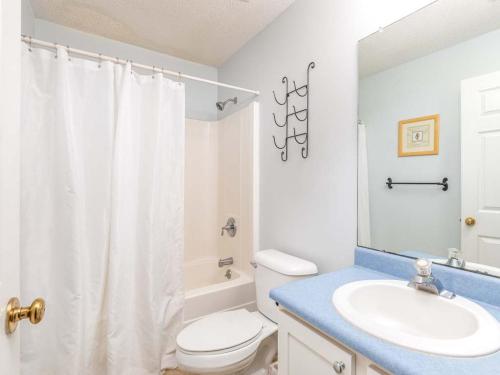 a bathroom with a white toilet and a sink at Beach Song in Tybee Island