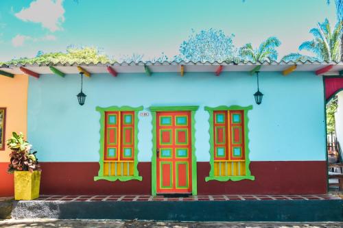 a wall with red and blue doors at Hotel Agroturistico Palma Vino in Arboletes