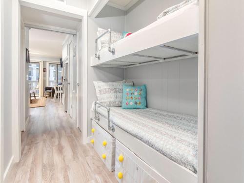 a small bedroom with a bunk bed and a staircase at Beach Racquet B202 in Tybee Island