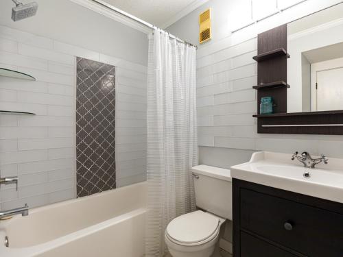 a white bathroom with a toilet and a sink at Beach Racquet B202 in Tybee Island