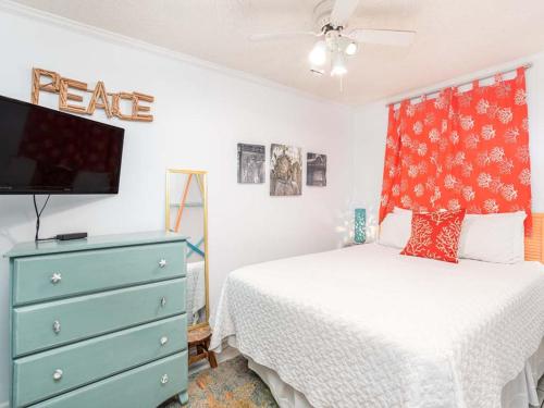 a bedroom with a bed and a dresser with a tv at Beach Racquet A330 in Tybee Island