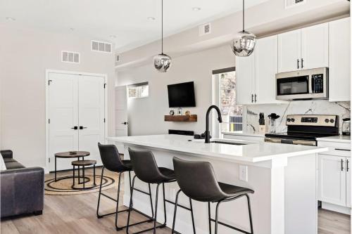 a kitchen with a large white counter and chairs at Golden Sanctuary Luxe Apt 1 Block From Main St in Golden
