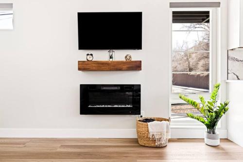 a living room with a flat screen tv on a wall at Golden Sanctuary Luxe Apt 1 Block From Main St in Golden