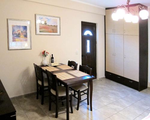 a dining room with a wooden table and chairs at Estia Holiday in Gythio