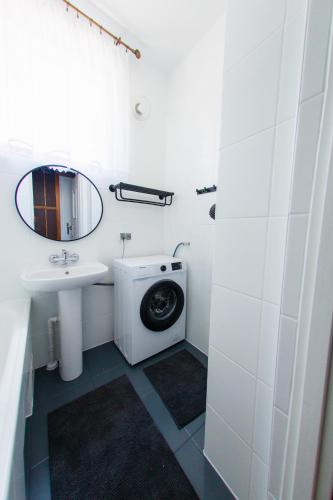 a bathroom with a sink and a washing machine at Dom z Widokiem in Augustów