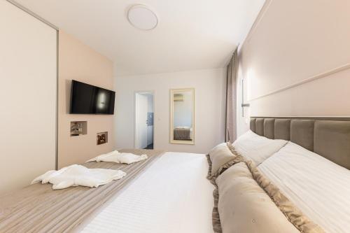 een slaapkamer met een groot bed en een flatscreen-tv bij Apartment Sasso in Split