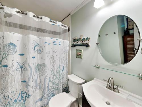une salle de bain avec un lavabo, des toilettes et un miroir dans l'établissement Beach Racquet A209, à Tybee Island