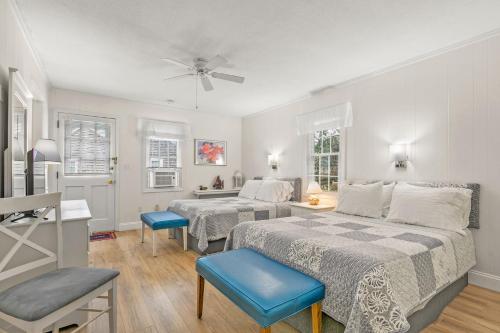 a bedroom with two beds and a table at The Cottages at Captain Gosnold Village in Hyannis